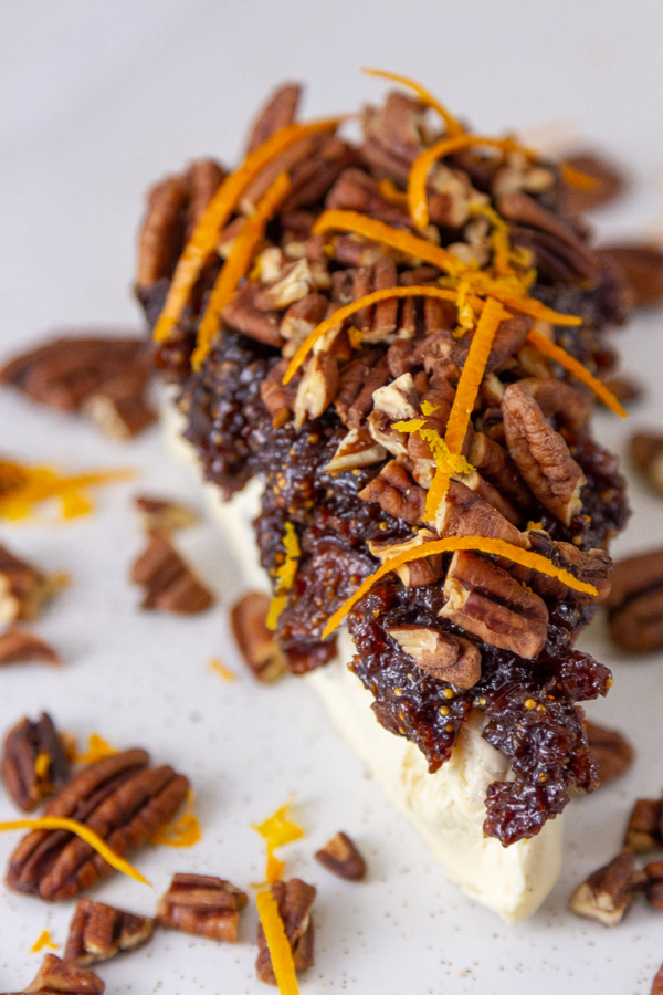 looking down on an appetizer of blue cheese with figs, pecans, and orange.