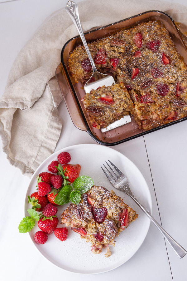 looking down on a slice of baked oatmeal next to the pan of oatmeal.