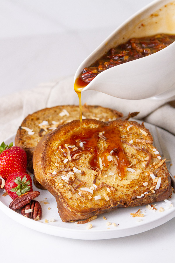 pouring butter pecan syrup over French toast slices.