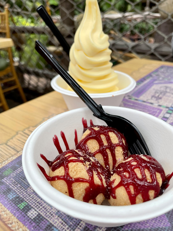 A bowl of PB&J mochi with a spoon, and a Dole whip in the background from Disneyland.