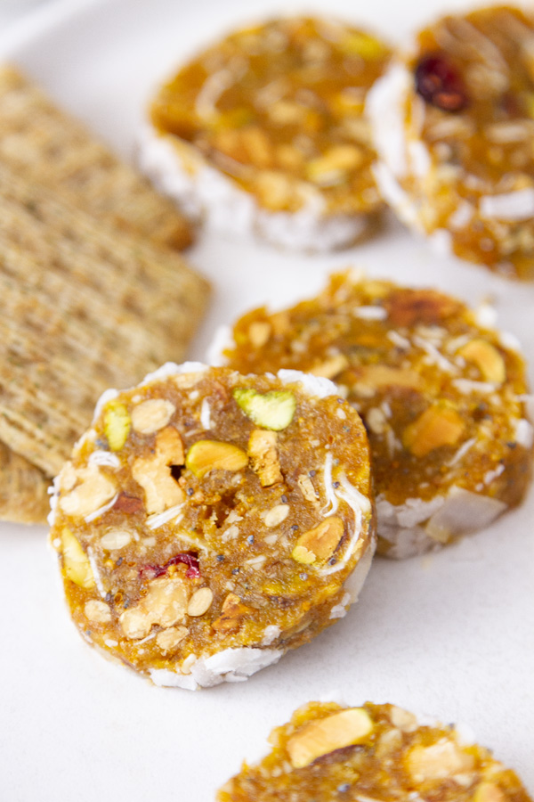 close up on the dried fruit and nut rolls with some crackers.