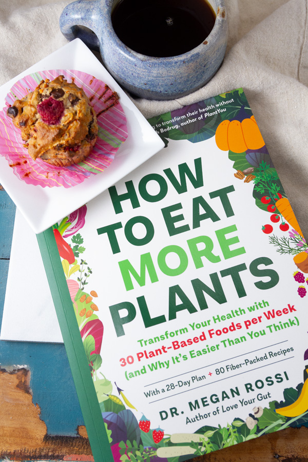 The book, How to Eat More Plants with a muffin and a cup of coffee next to it.