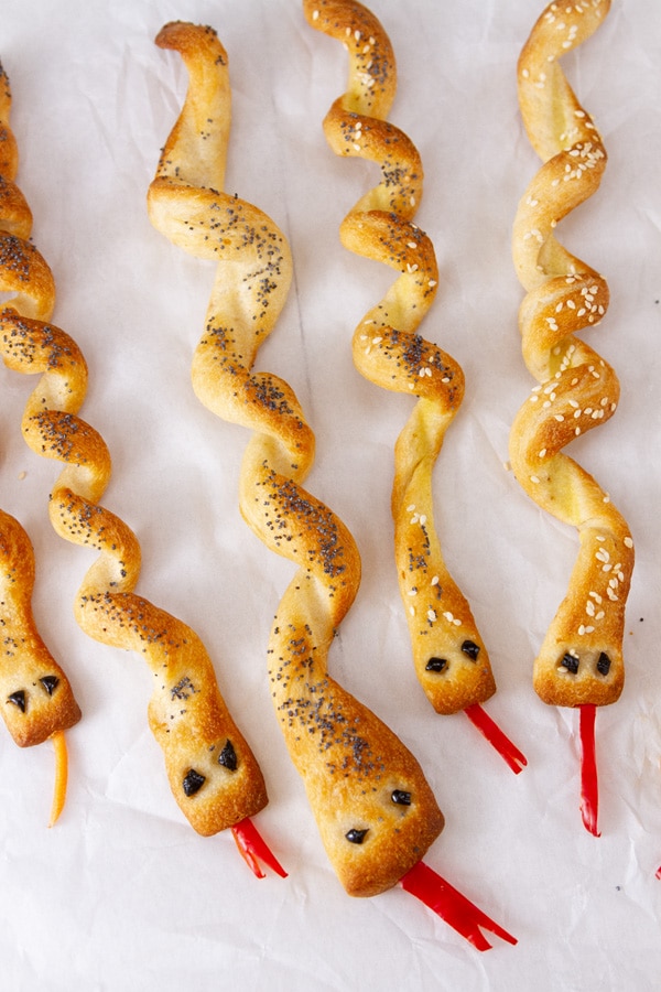 5 snakes made out of bread on a white background.