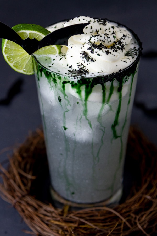 a drink in a stick wreath with a bat and a lime wheel for garnish.
