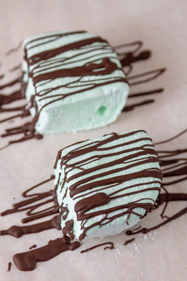 green homemade marshmallows drizzled with melted dark chocolate.