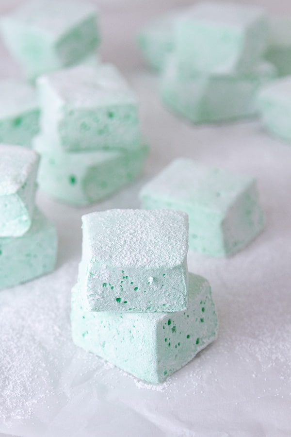 Parchment paper with stacks of mint marshmallows on top.