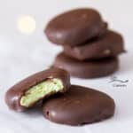 square crop homemade mint candies stacked up, one has a bite missing so you can see the inside.