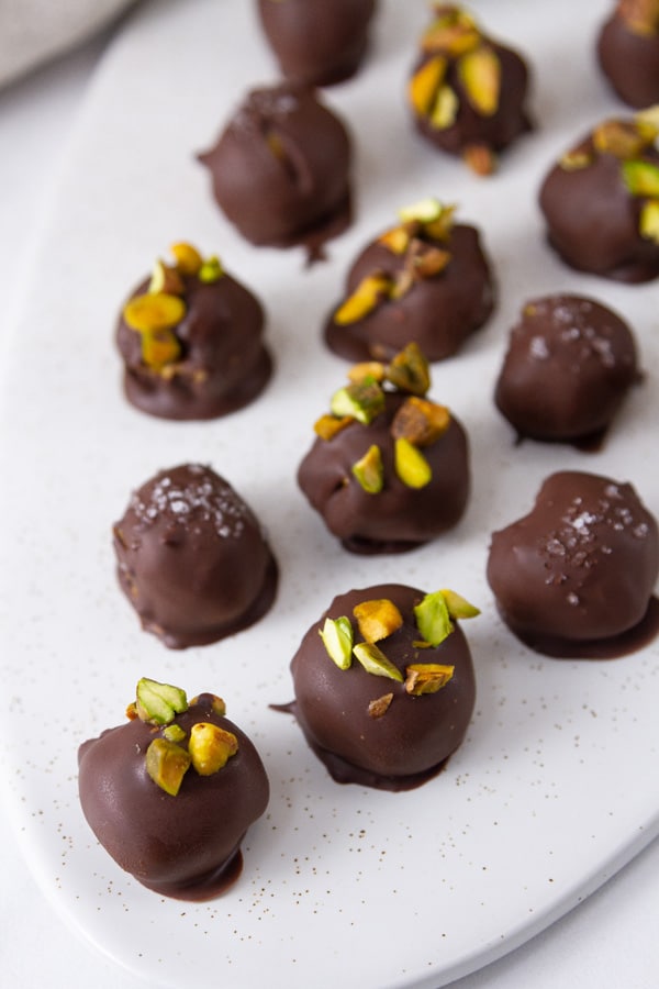 Looking down on a white plate filled with chocolate candy truffles.