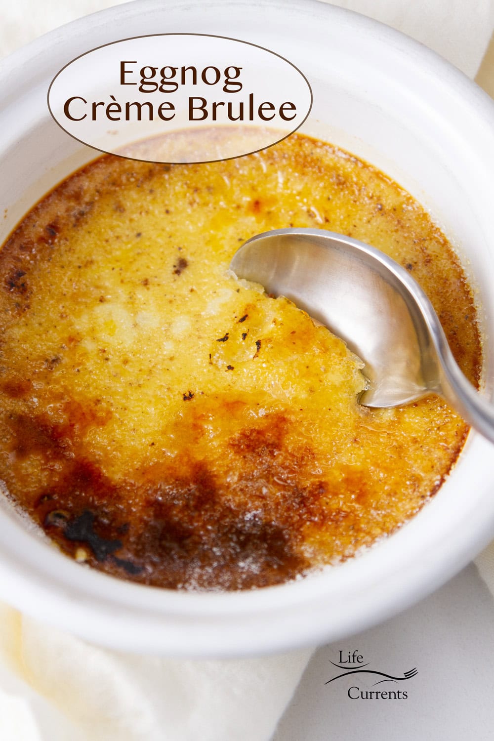 close up on an eggnog creme brulee with a spoon in it.