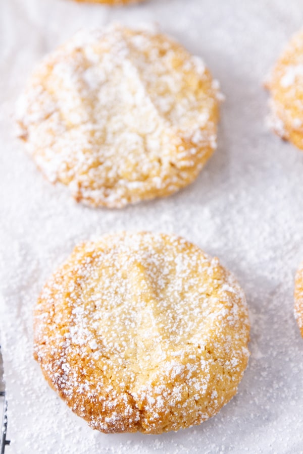 close up on almond cookies dusted with powdered sugar.