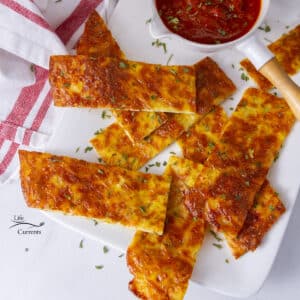 looking down on a plate filled with keto breadsticks and a dish of marinara.