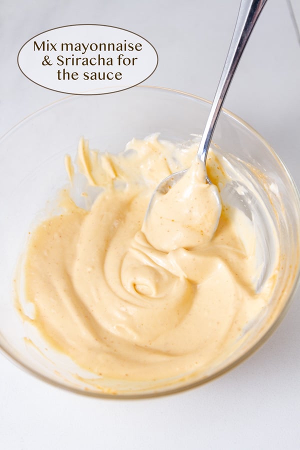 spicy sriracha mayo in a glass bowl with a spoon in it.