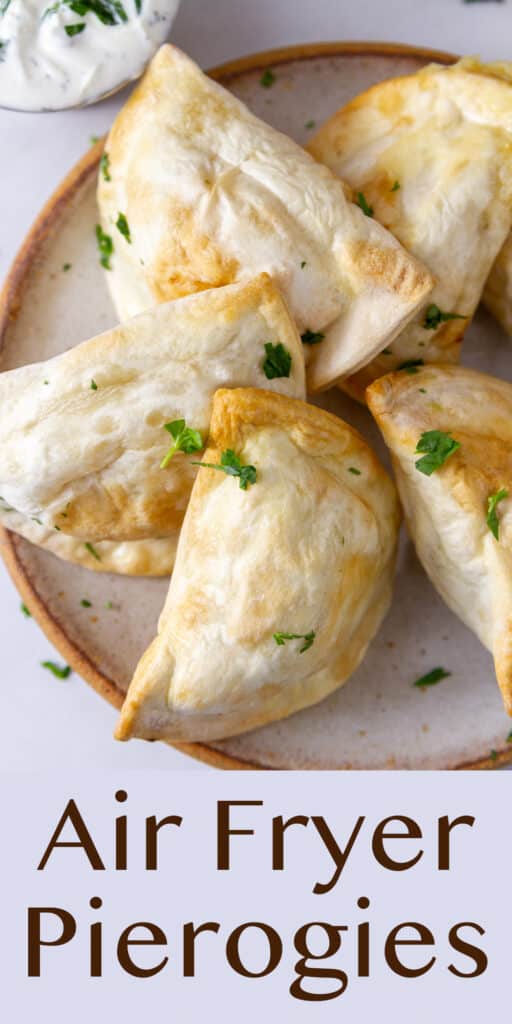 5 pierogies on a plate in a fan shape, a cup of ranch next to them.