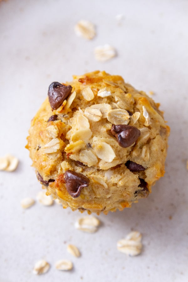a single muffin viewed from the top with some oats scattered around it.