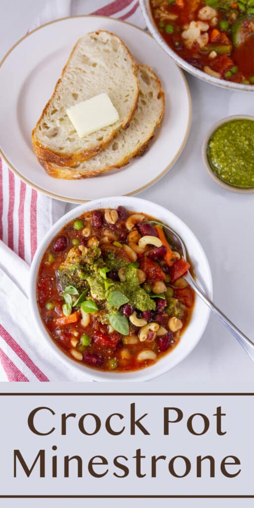 Looking down on a bowl of minestrone soup served with slices of bread and a dish of pesto next to a cloth red striped napkin.