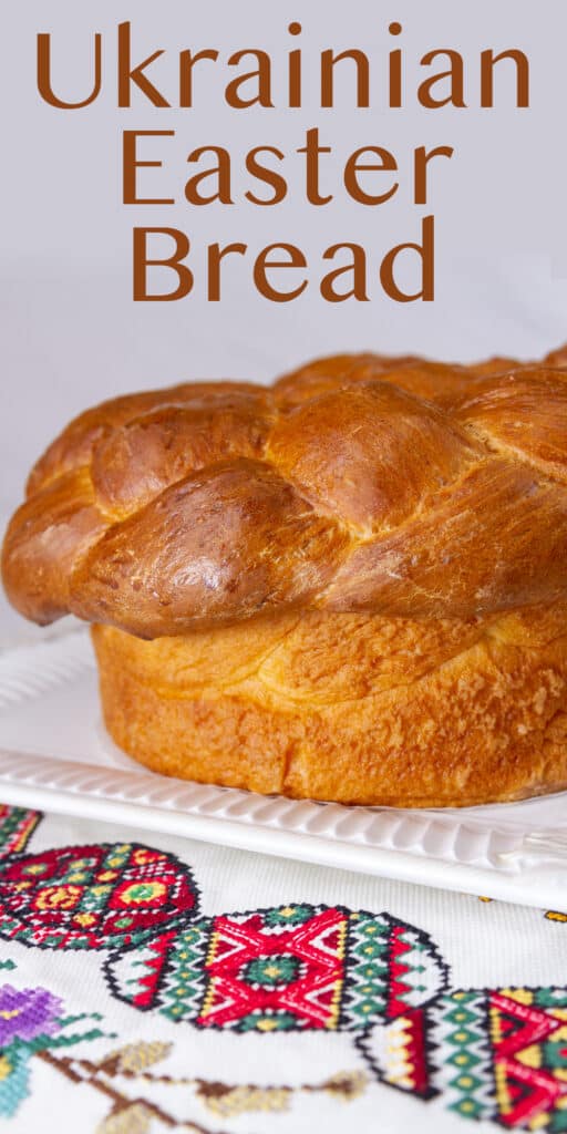 Ukrainian Easter Bread loaf on a white platter on embroidered pysanky  eggs linen.