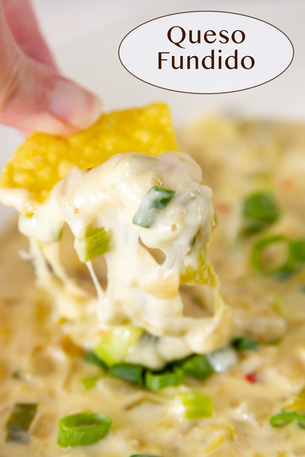 a tortilla chip scooping cheese dip up and there's the cheese pull.