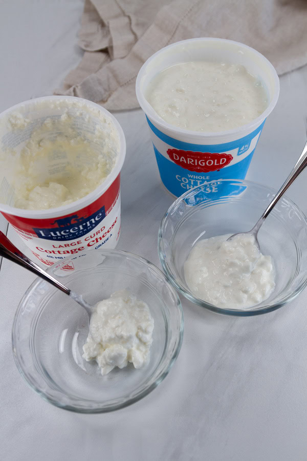 two different brands of cottage cheese in the containers and spooned out into dishes.