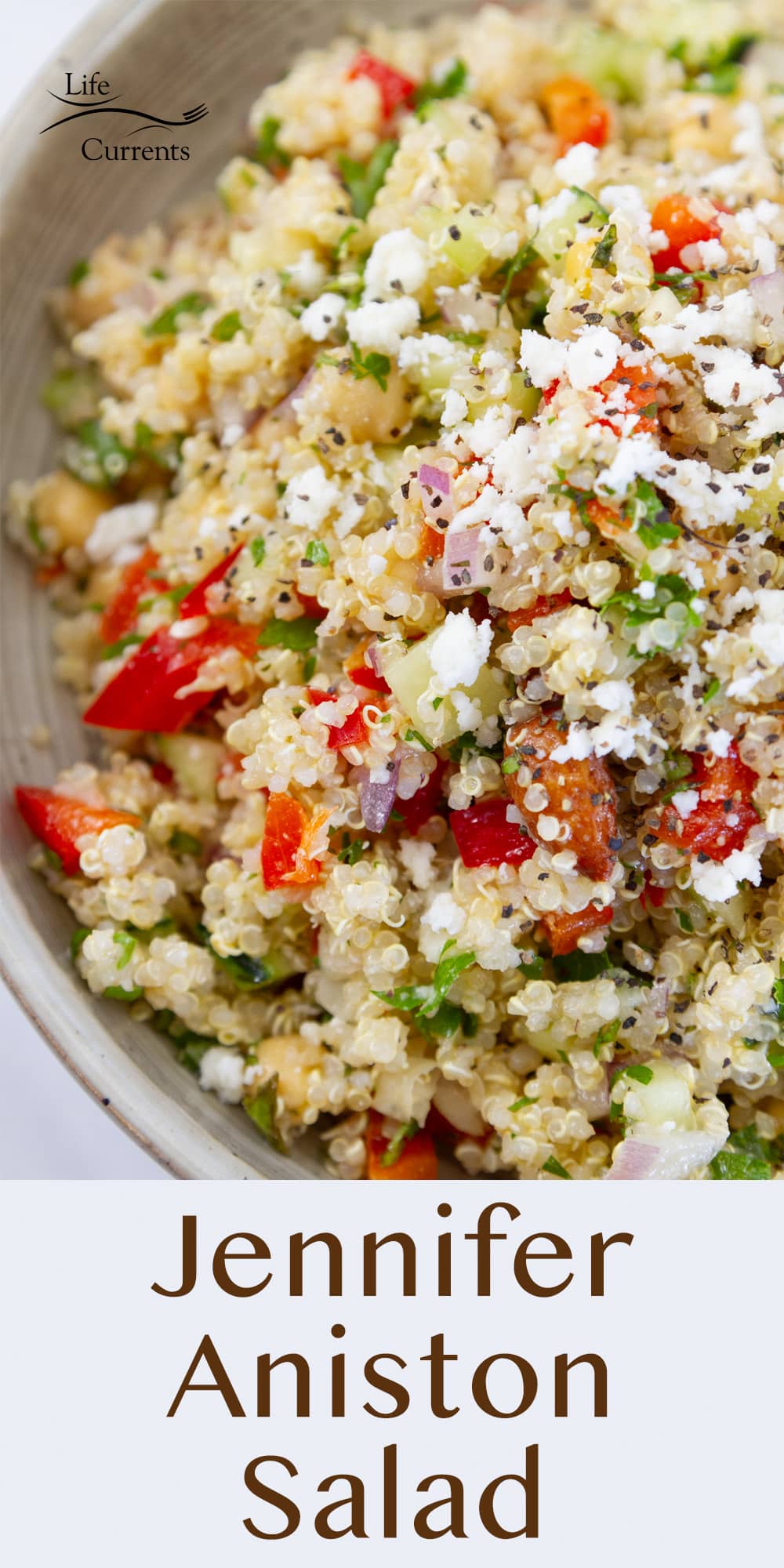 looking down into a big bowl of quinoa salad with veggies and cheese.