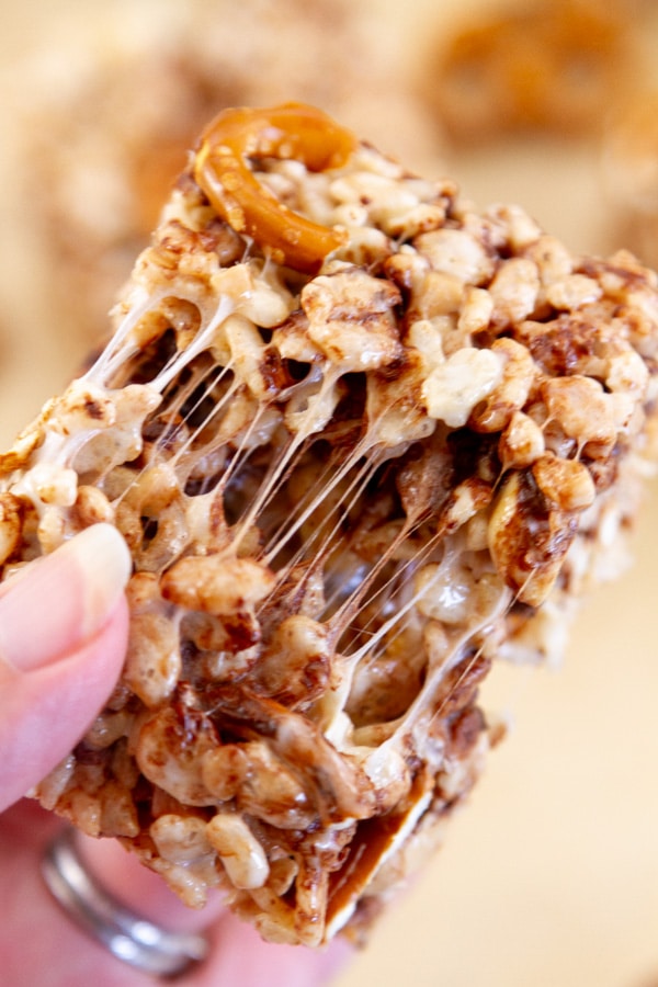 a rice crispy treat being pulled apart so you can see the gooey marshmallow inside.