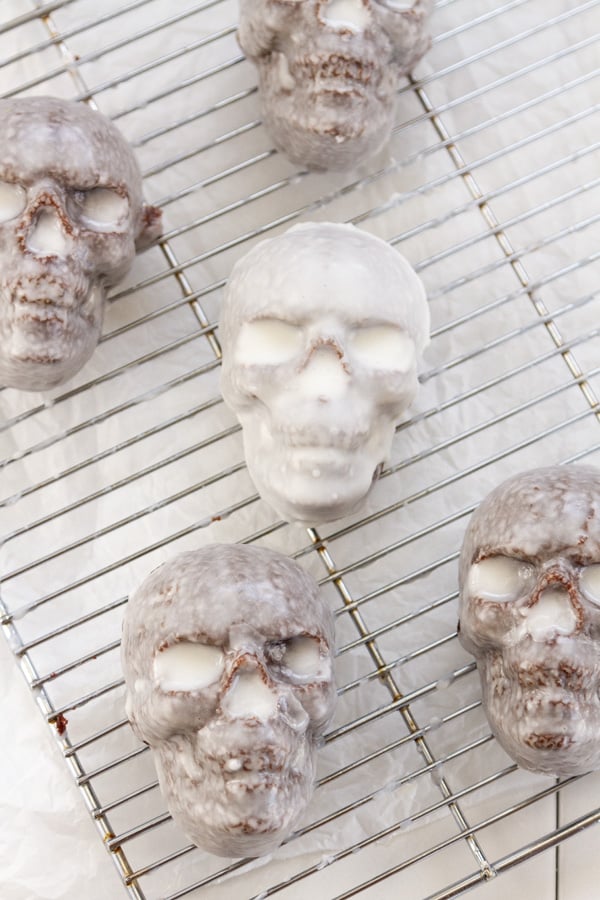 skull cakes on a wire cooling rack after being glazed.
