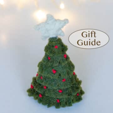 a small felt Christmas tree in font of some twinkle lights and the title "gift guide" is to the right.
