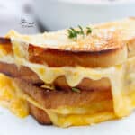 square crop of a grilled cheese sandwich that's cut in half and stacked.