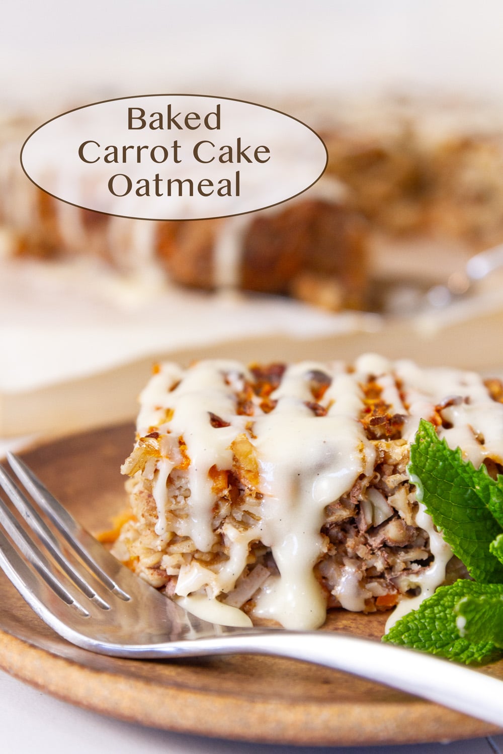a slice of baked carrot cake oatmeal drizzled with cream cheese icing on a plate with a fork and a mint sprig.