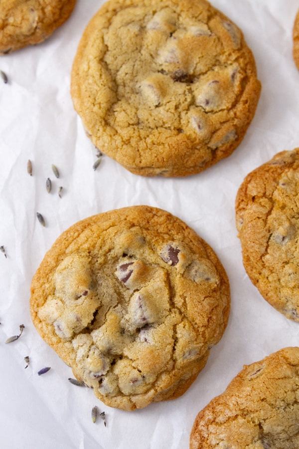 baked cookies on white parchment paper with lavender buds around them.