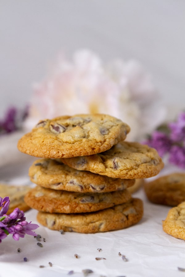a stack of cookies in front of some flowers.
