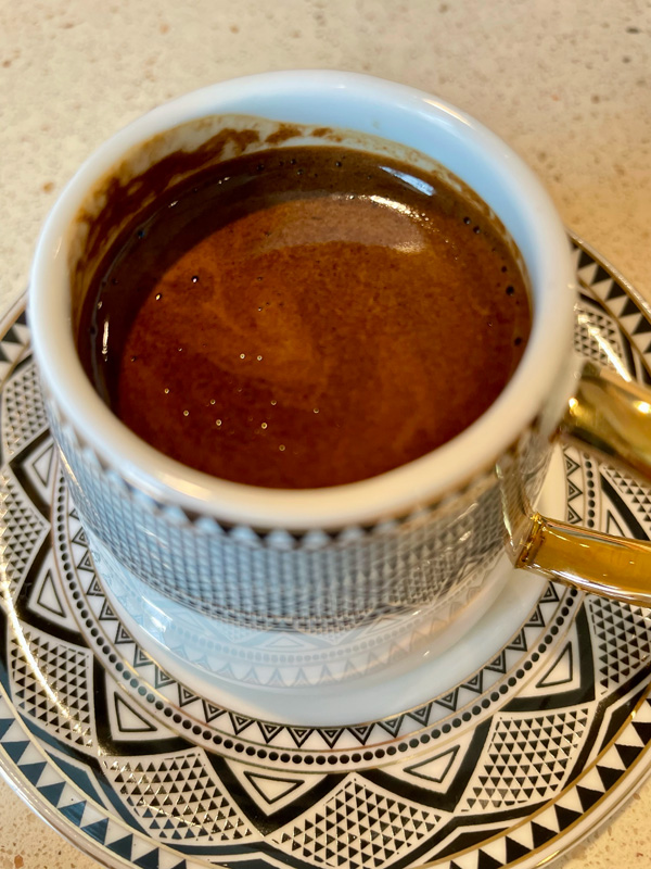 a Turkish Coffee on a black and white plate.
