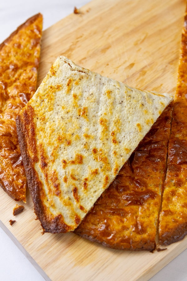 Flatbread cut apart and one slice folded in half so you can see the underside.