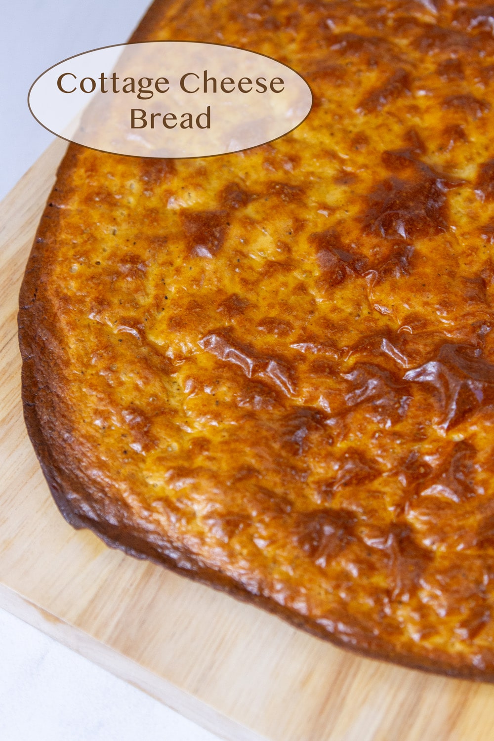 cottage cheese flatbread on a wooden cutting board.