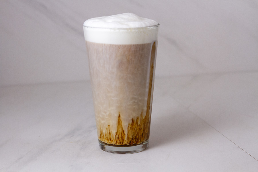 horizontal crop of a glass ice iced coffee with cold foam.