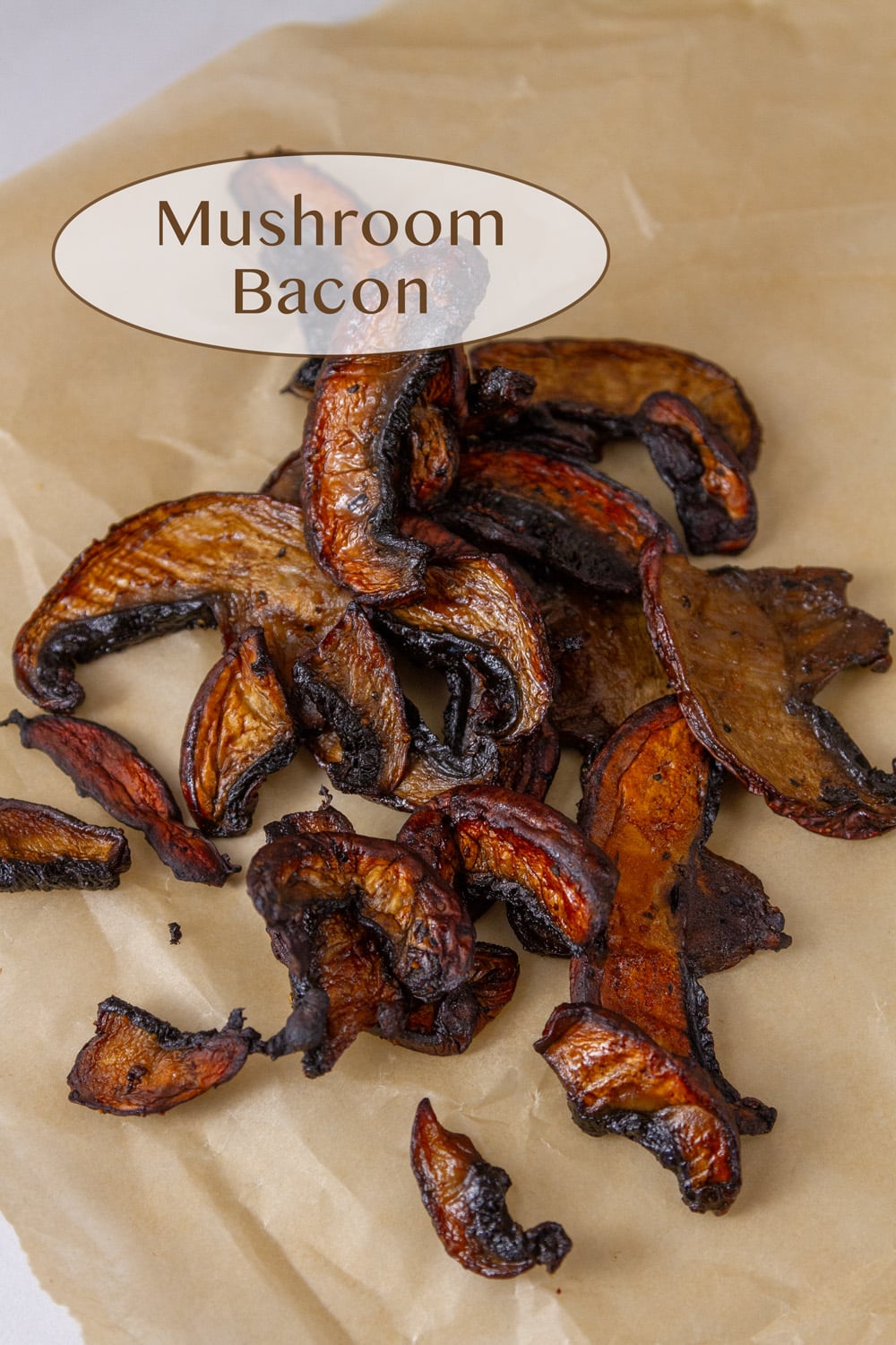 cooked mushrooms with crispy edges in a pile on a piece of brown parchment paper.