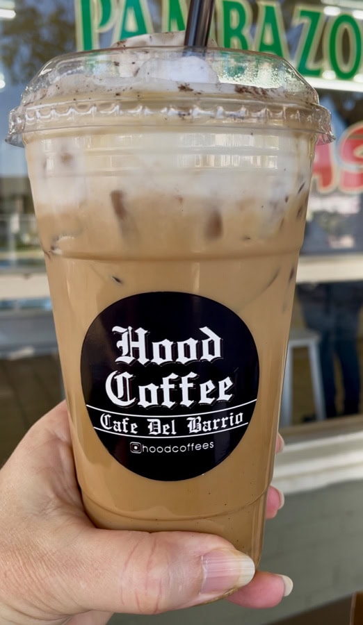 an iced coffee from Hood Coffee being held by a hand.