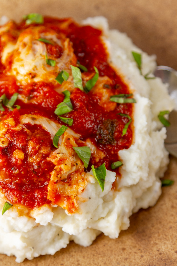 meatballs in red sauce and cheese over mashed potatoes.