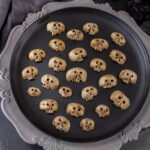 square crop of mushroom skulls on a black plate on a concrete charger.