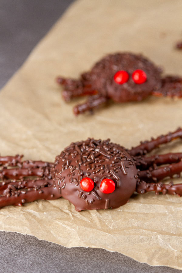 chocolate spider cookies on brown parchment paper.