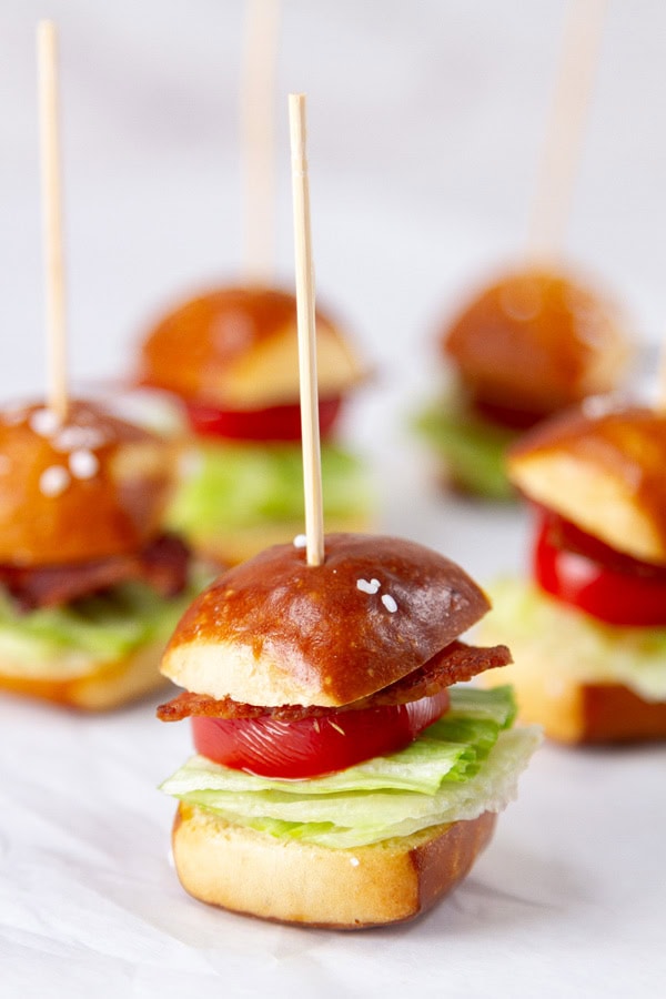 BLT sandwiches on mini pretzels on a white background.