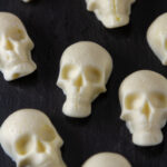 square crop of edible Halloween skulls on a black background.