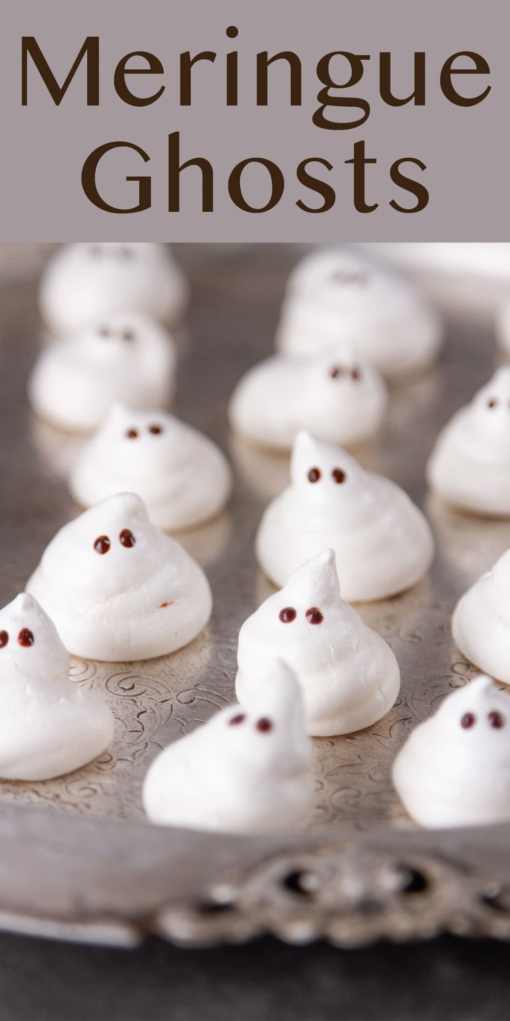 several meringue ghosts on a pewter platter.