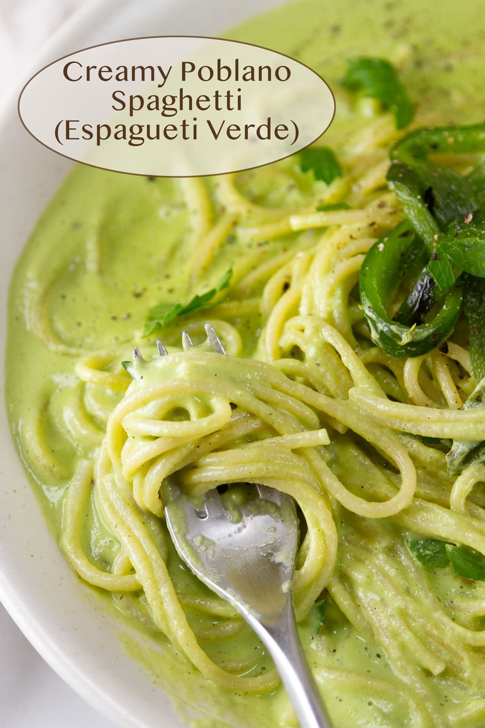 spaghetti noodles in a creamy green sauce with a fork twirling the noodles.