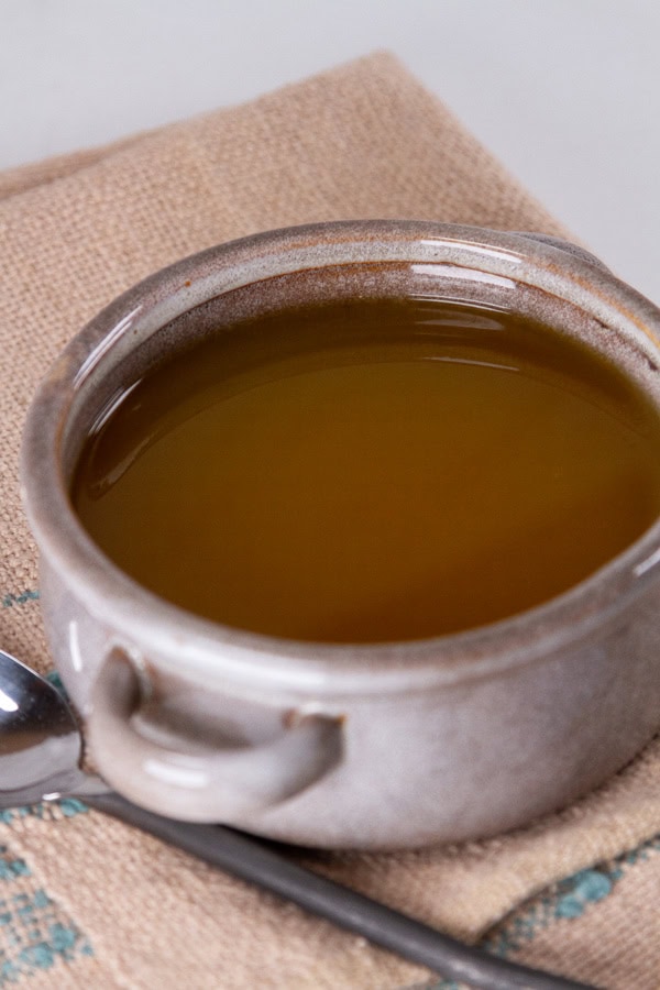 a bowl of soup on a cloth with a spoon.