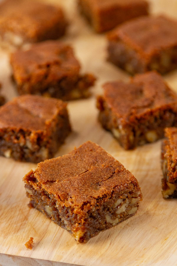 bar cookies with nuts on a wooden cutting board.