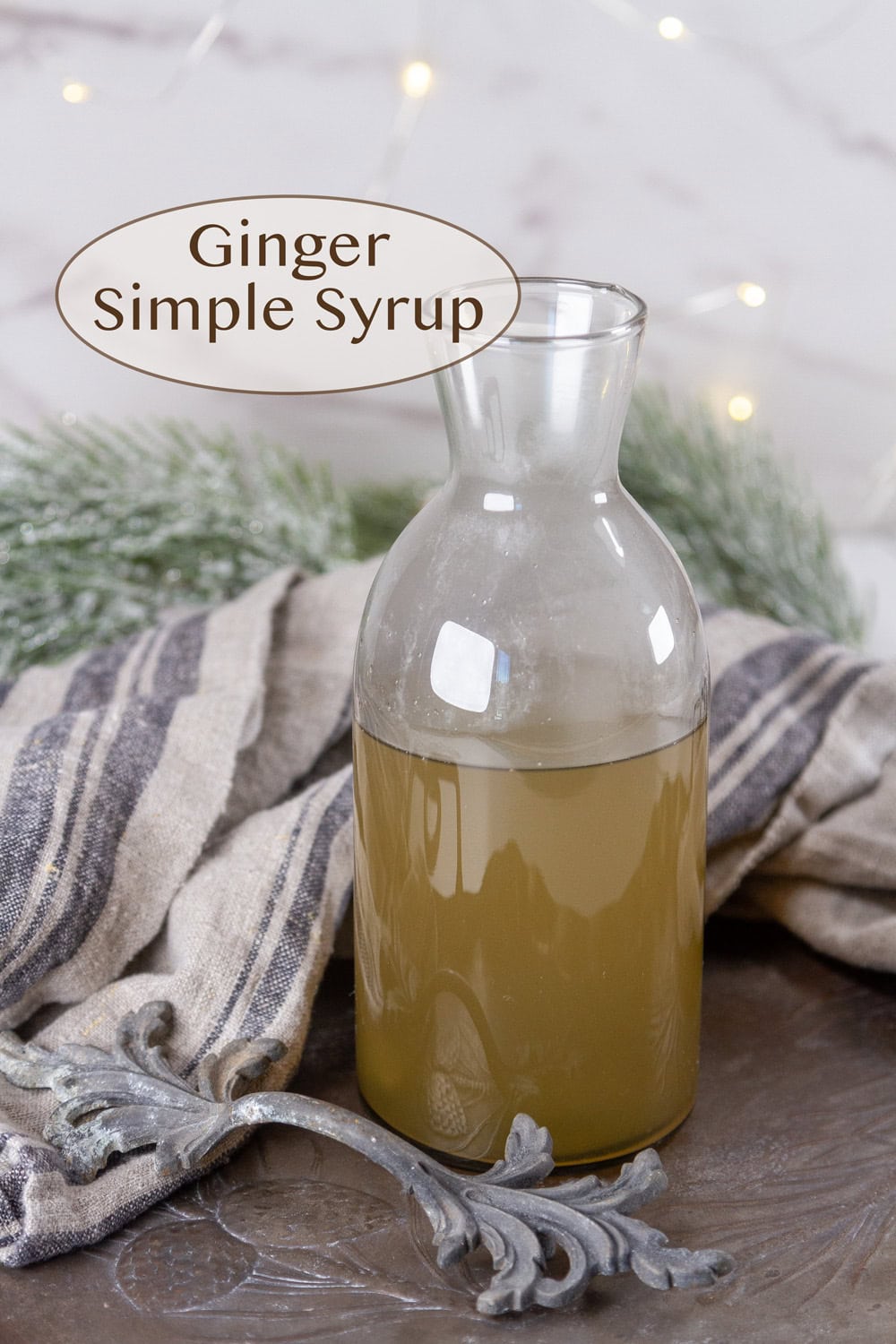a glass jar of ginger simple syrup in front of a wintry scene.
