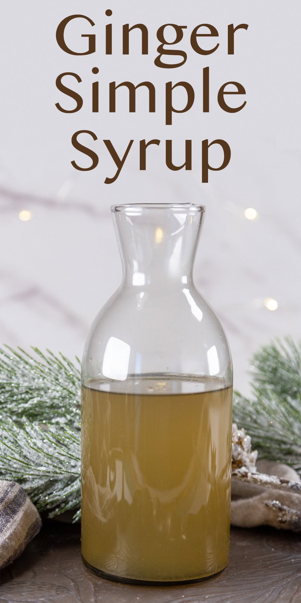 a bottle of simple syrup in front of greenery.