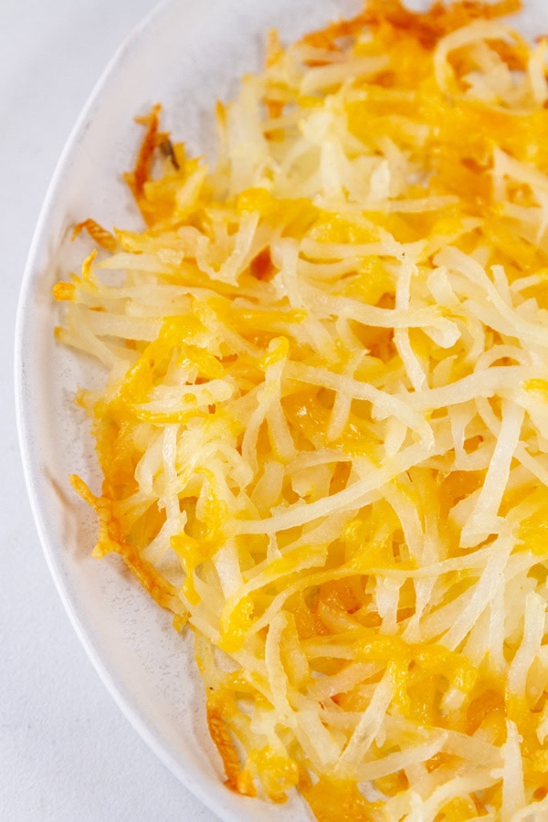 close up on hashbrowns on a white plate.