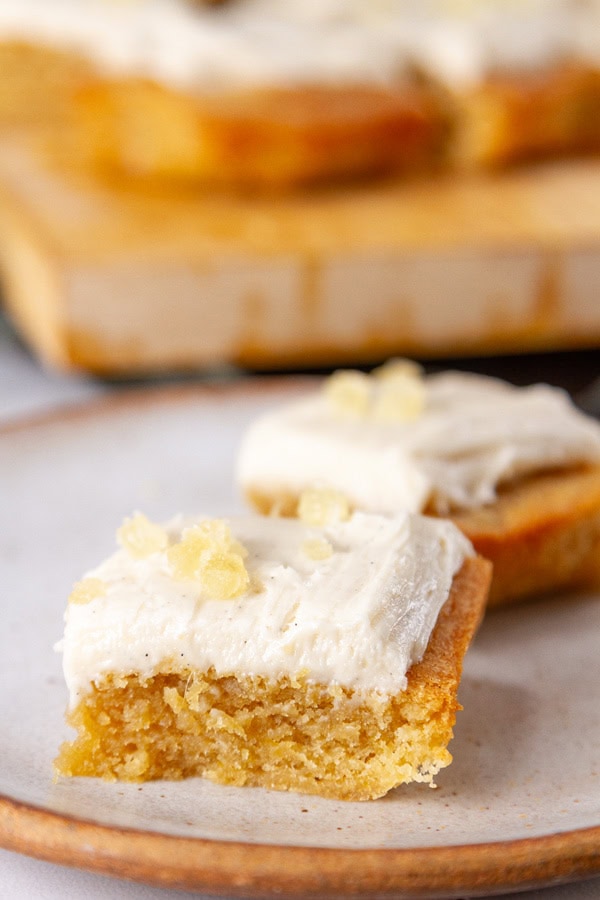 two frosted dessert bars on a white plate.