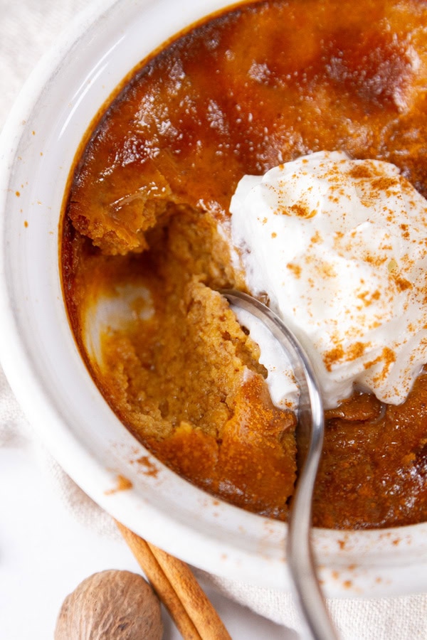 a spoon taking a bite out of a pumpkin custard.